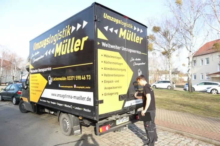 umzugshelfer verpackt polstermoebel mit schutzplane